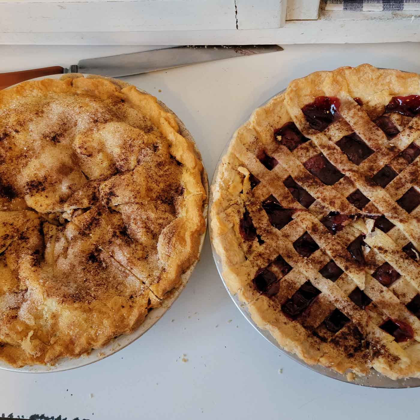Two homemade pies on a counter.
