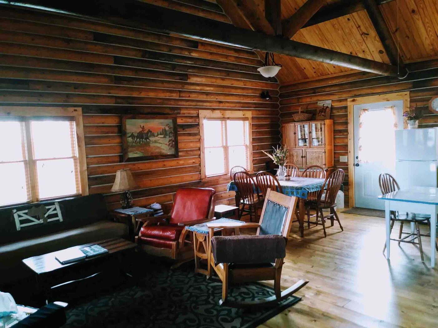 triangle-ranch-cabin-under-the-hill-9 Main area with wooden cabinets, stove, and dining area.