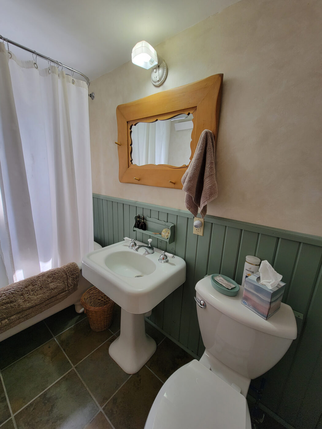triangle-ranch-cowboy-carriage-house-10 Bathroom with sink, mirror, and tub.