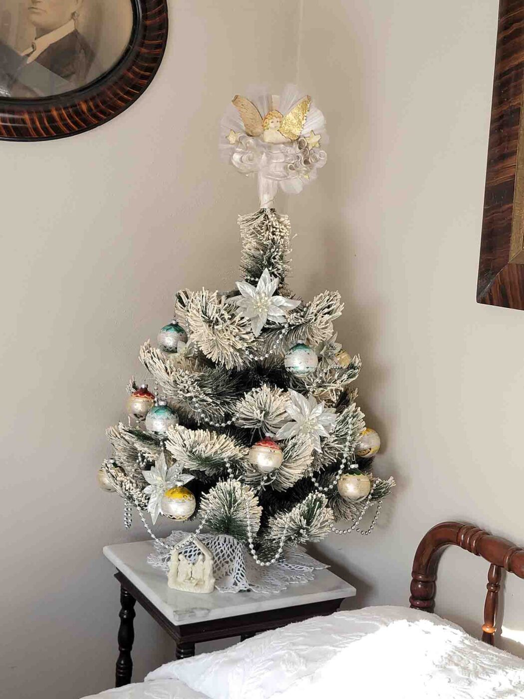 triangle-ranch-esthers-room-5 Christmas tree beside a cozy cabin bed during winter stay.